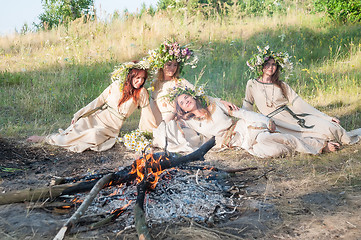 Image showing Beautiful women with flower wreath near bonfire