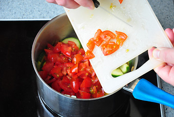 Image showing Cutted tomatoes in a pot on the cooker  while frying