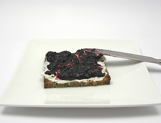 Image showing Wholemeal bread with cream cheese and bilberry jam on a plate wi