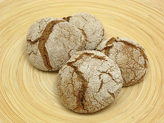 Image showing Home made wholemeal vinschgauer buns on wooden underlay