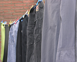 Image showing Clothesline outside the house with some laundered clothes 