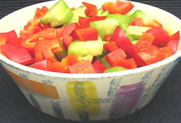 Image showing Slices of cucumber and red pepper in a ceramics bowl