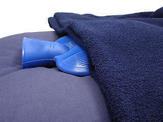 Image showing Blue hot-water bag wrapped in a blue blanket on a blue pillow