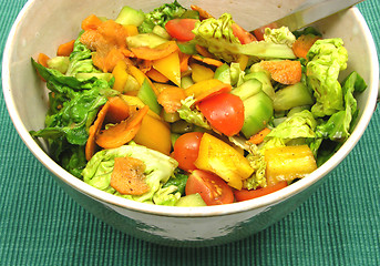 Image showing Assorted salad in pottery bowl with green background