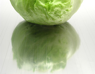 Image showing Green iceberg lettuce on gray reflecting mat 