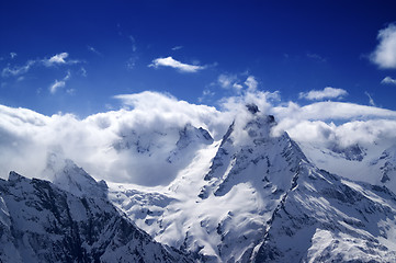 Image showing Snowy mountains in sunlight clouds