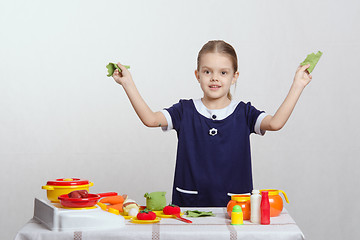 Image showing Girl in the kitchen with cabbage leaves