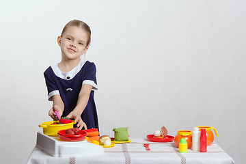 Image showing Girl hostess prevents spoon in the pan