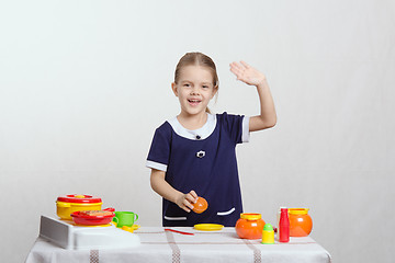 Image showing Girl waving a toy kitchen