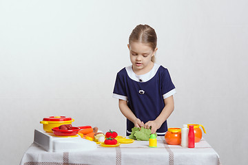 Image showing Girl cut up head of cabbage