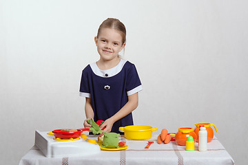 Image showing Five year old girl puts cabbage leaf in pan