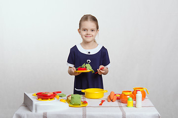 Image showing Five-year hostess holds plate with a dish and spoon