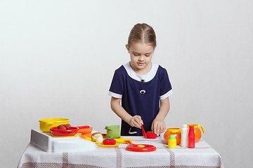 Image showing Girl enthusiastically cuts tomato