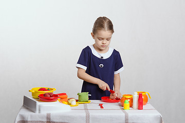 Image showing Girl cuts a toy mushroom in the kitchen