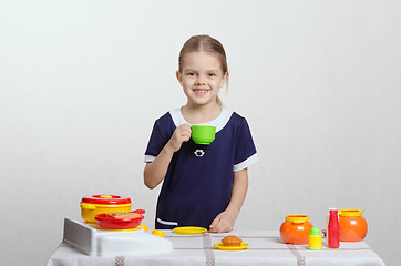 Image showing Girl drinking from the cup at her kitchen