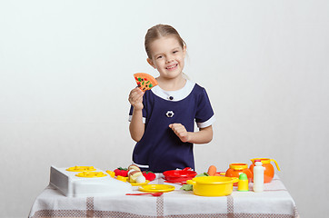 Image showing Girl with smile holding a pizza cooked in kitchen