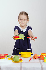 Image showing Five-year hostess offers plate of food and a spoon