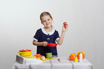 Image showing Girl hostess puts chicken in the pan