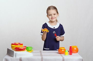 Image showing Girl with a toy kitchen pie