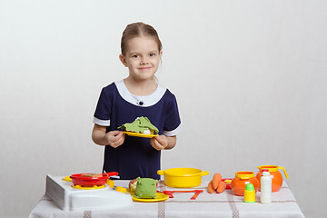 Image showing Five year old girl a plate with dish