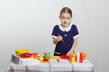 Image showing Funny girl cuts a tomato