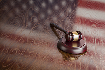 Image showing Wooden Gavel Resting on Flag Reflecting Table