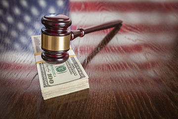 Image showing Wooden Gavel Resting on Money with American Flag Reflection