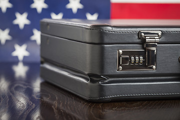 Image showing Leather Briefcase Resting on Table with American Flag Behind