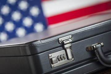 Image showing Leather Briefcase Resting on Table with American Flag Behind