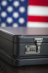 Image showing Leather Briefcase Resting on Table with American Flag Behind