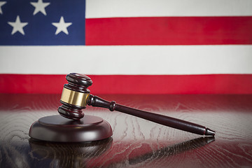 Image showing Wooden Gavel Resting on Flag Reflecting Table