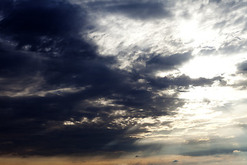 Image showing Sun on sky and dark storm clouds