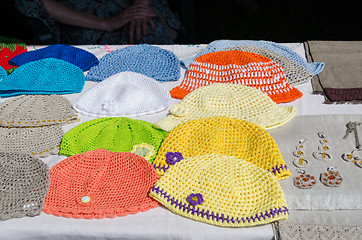 Image showing crocheted colorful baby hat lying on stall fair 