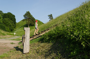 Image showing tourist girl climb strairs on mound hill 