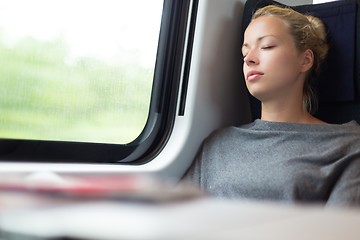 Image showing Lady traveling napping on a train.