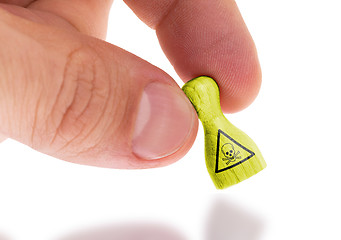 Image showing Hand holding wooden pawn, painting, selective focus