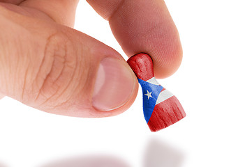 Image showing Hand holding wooden pawn, flag painting, selective focus