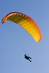 Image showing Orange paraglider in a blue sky