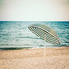 Image showing Striped umbrella on sandy beach