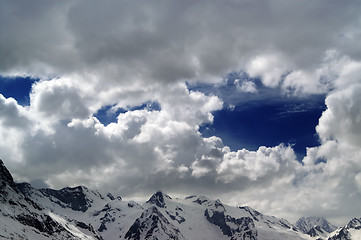 Image showing Snowy mountains in beautiful clouds