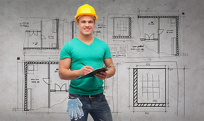 Image showing smiling man in helmet with clipboard