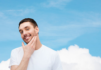 Image showing beautiful smiling man touching his face
