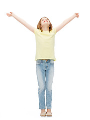 Image showing smiling teenage girl with raised hands