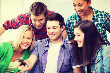 Image showing students looking into smartphone at school