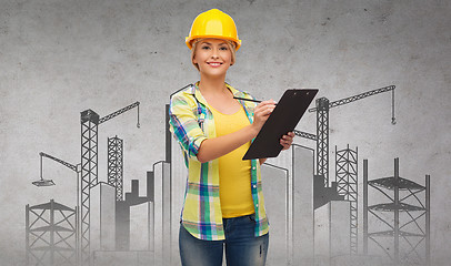 Image showing smiling woman in helmet with clipboard