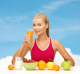 Image showing smiling young woman eating healthy breakfast