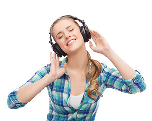 Image showing young woman listening to music in headphones