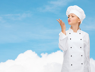 Image showing smiling female chef showing delicious sign