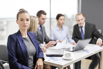 Image showing businesswoman in office with team on the back