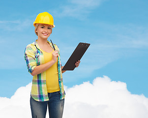 Image showing smiling woman in helmet with clipboard